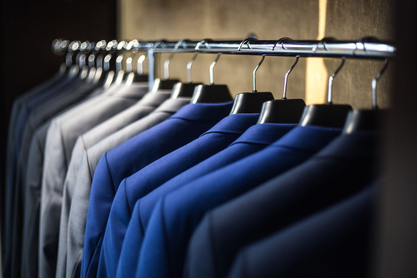 Blue and gray tailored jackets arranged on a rail